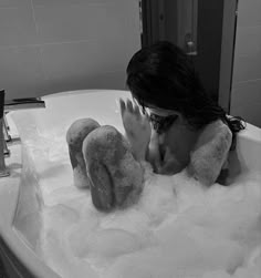 a woman laying down in a bathtub filled with foam