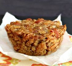 a muffin sitting on top of a piece of wax paper covered in toppings