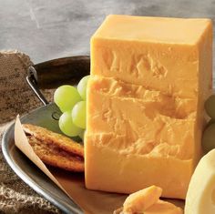 a plate with grapes, cheese and bread on it