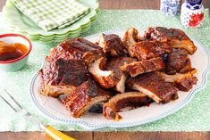 a plate full of ribs and sauce on a table