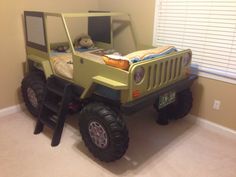 a green jeep bed in the corner of a room with a stuffed animal on it