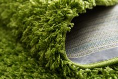 a close up view of the corner of a green rug