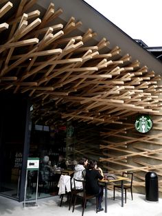 two people sitting at a table in front of a starbucks