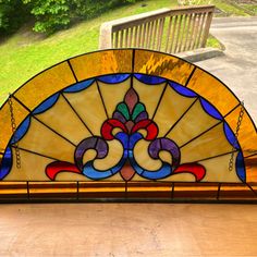 a stained glass window with an ornate design on the front and side panels, sitting on a wooden table