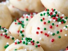 white cookies with green and red sprinkles are arranged in a pile on a table