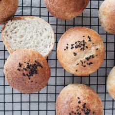 several loaves of bread on a cooling rack with seeds sprinkled on them