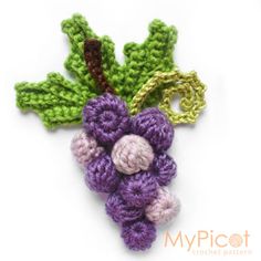 a crocheted brooch with leaves and flowers on it's back side