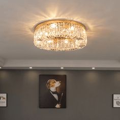 a chandelier hanging from the ceiling in a room with pictures on the wall