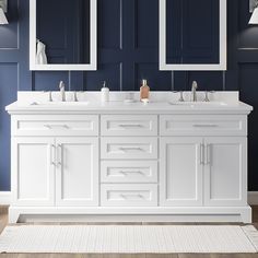 a bathroom with blue walls and white double sink vanity, two mirrors on the wall