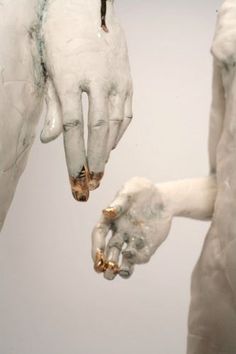 two hands touching each other with white paint on them