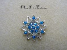 a snowflake brooch with blue crystals on it