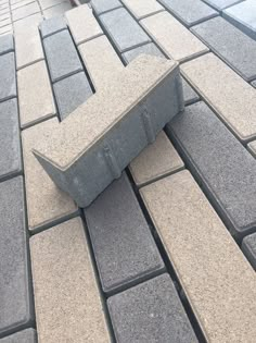 a stone bench sitting on top of a sidewalk