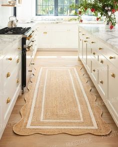 an old fashioned kitchen with white cabinets and wood floors