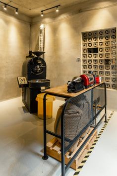 a coffee machine sitting on top of a wooden table next to a metal rack filled with bags