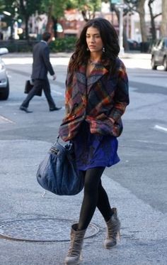 a woman walking down the street carrying a purse