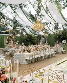 an outdoor wedding reception setup with white and green linens, floral centerpieces and gold chairs