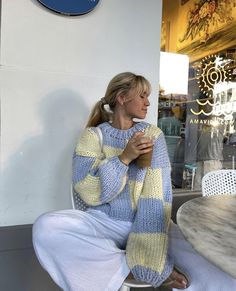 a woman sitting on a chair holding a cup