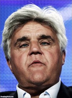 a close up of a person wearing a suit and tie in front of a blue background