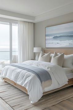 a large bed sitting next to a window in a room with white walls and wooden flooring