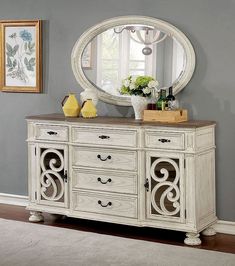 a white dresser sitting in front of a mirror