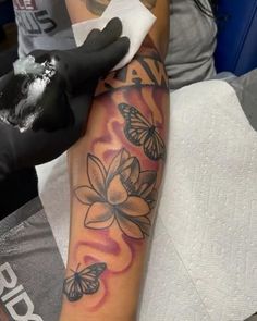 a person with a tattoo on their arm holding a white glove and cleaning the leg