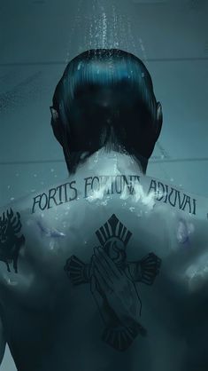 the back of a man's head with tattoos on his chest and hands under water