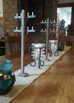 candles are lined up on the table in front of an empty glass bowl and candle holder