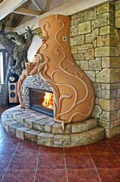 a large fireplace in the middle of a living room with stone walls and flooring