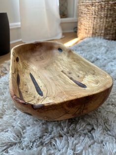 a wooden bowl sitting on top of a white rug