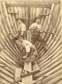 an old photo of men working on a boat