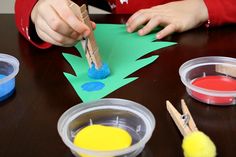 a child is making christmas trees out of construction paper