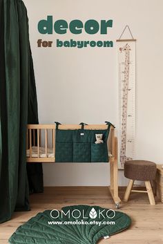 there is a baby crib next to a green blanket on the floor in front of a window