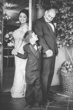 a young boy and woman standing next to each other in front of a door with their hands on the child's chest