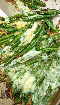 asparagus and cheese covered dish in pan with spoon