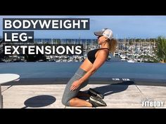 a woman sitting on top of a table next to a bodyweight leg extensions