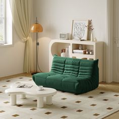 a living room with a green futon couch and coffee table in the corner, next to a window