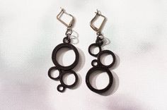 two pairs of black metal earrings on a white background with the word o written in it