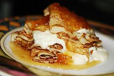 a plate topped with crepes covered in cream