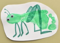 a paper plate with a drawing of a green bug on it's side and the letter l