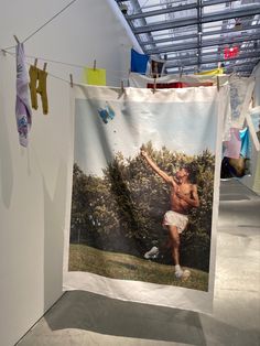 a photo hanging on a clothes line in an art gallery with laundry hanging to dry