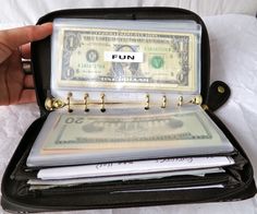 a person holding a wallet with money in it and the word fun written on it