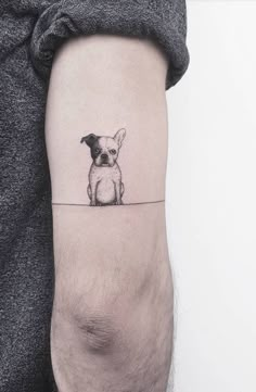 a small dog tattoo on the arm