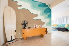 a living room with a surfboard on the wall