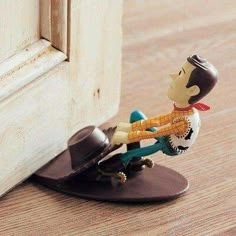 a small figurine is sitting on top of a skateboard near a door