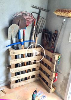 a wooden crate filled with gardening utensils on top of a floor next to a wall