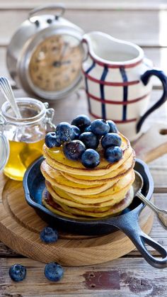 a stack of pancakes with blueberries and syrup