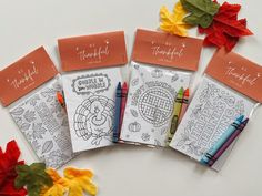 four thanksgiving coloring pages with colored pencils and leaves on the table next to them