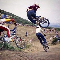 two people on bikes doing tricks in the air