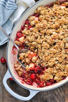 cranberry apple crisp in a white dish with a spoon