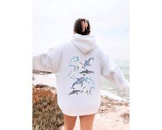 Dive into a sea of style with our Oversized Shark Sweatshirt! This fin-tastic piece is perfect for shark enthusiasts and marine life lovers alike. Featuring intricately embroidered designs of the magnificent whale shark, hammerhead, and bull shark, this sweatshirt is a unique and stylish tribute to these awe-inspiring creatures. Made for comfort and style, it's not just a garment; it's a statement of your passion for sharks and ocean conservation. Whether you're exploring the depths of the sea or enjoying a cozy day indoors, this sweatshirt is a must-have for those who want to make waves with their fashion. Join the movement to save the sharks and showcase your love for marine life with this trendy and comfortable sweatshirt. It's the perfect gift for any shark enthusiast or a great additi Shark Sweatshirt, Vsco Hoodie, Vintage Hoodies, Fall Sweatshirt, Fleece Sweatshirt, Girls Fashion Clothes, Womens Clothing Sizes, Casual Pullover, Casual Hoodie